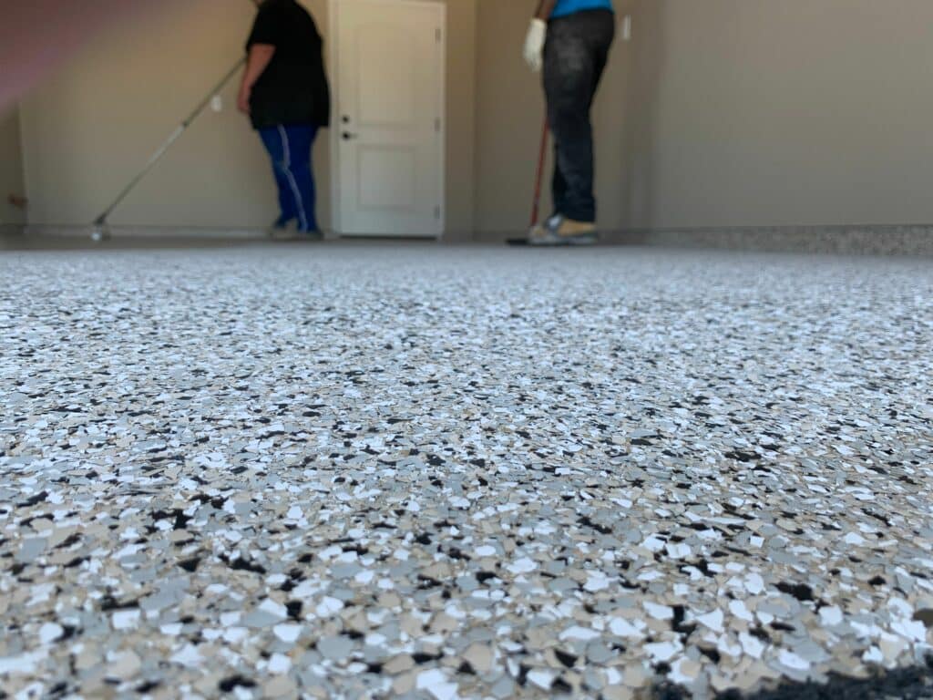 workers finishing coated garage floor